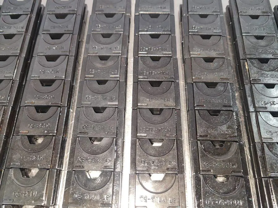 A batch of machined dies laid out in rows