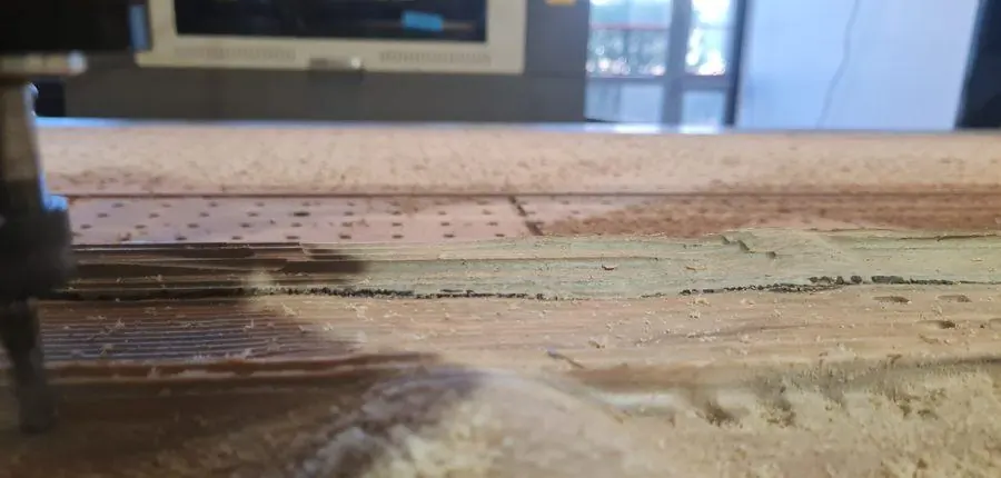 The surfacing cutter mid-pass across a reclaimed board