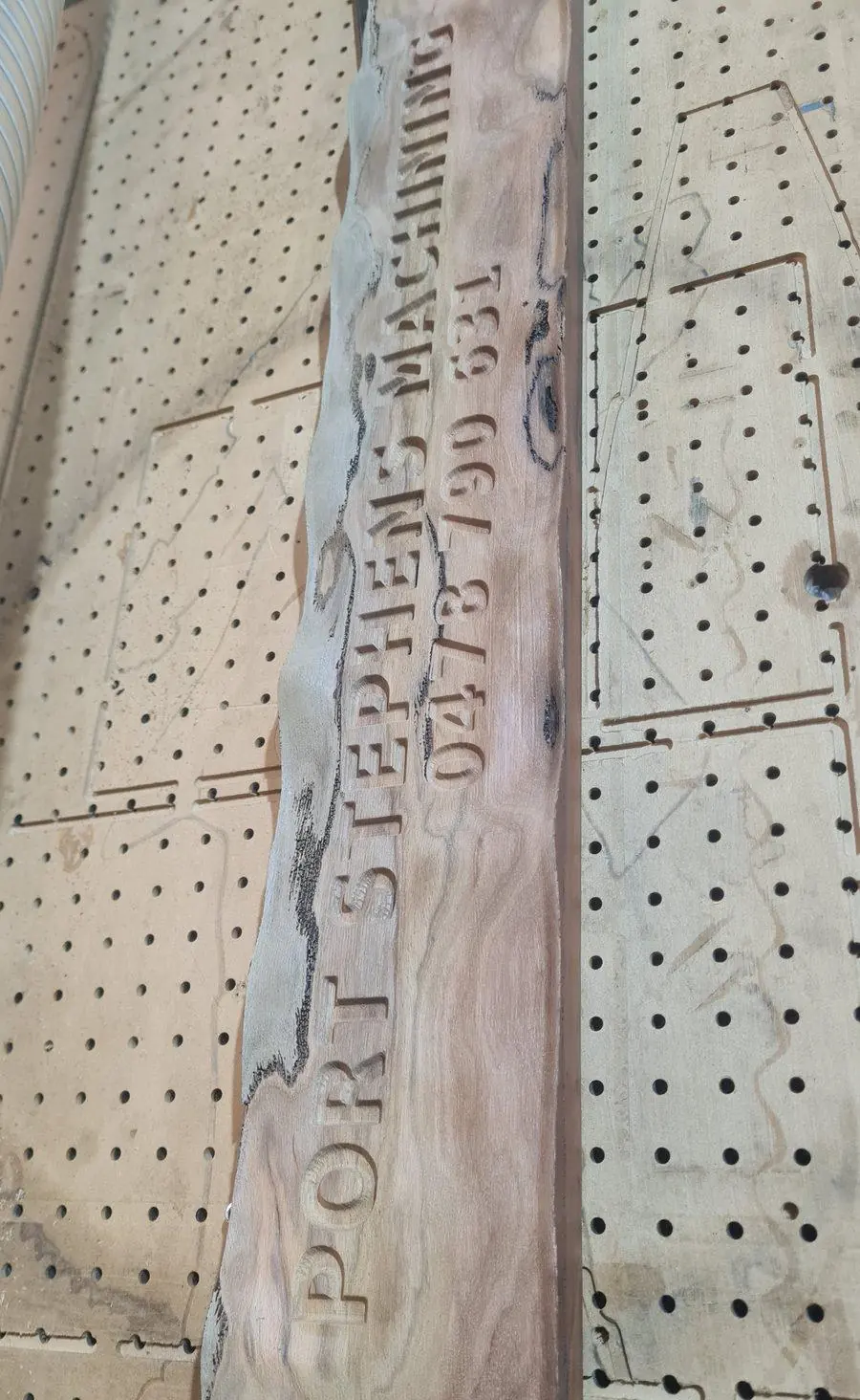 A carved timber name plaque on the router bed